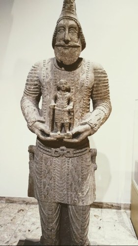 A limestone statue representing one of the leaders in the army of Hatra, wearing his Military uniform and holding a baby, found in the fourth temple in Hatra (312-139 BCE).